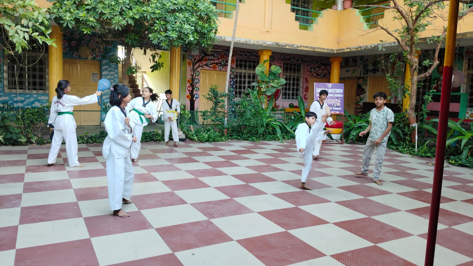 Students practicing taekwondo together in the courtyard